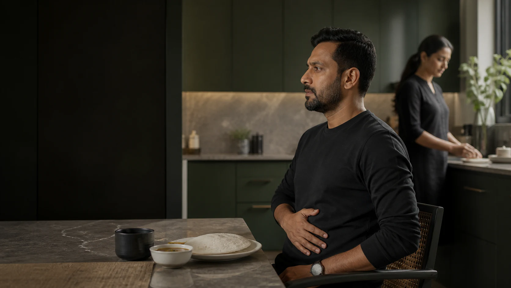 A man experiencing recurring digestive discomfort before a meal at home