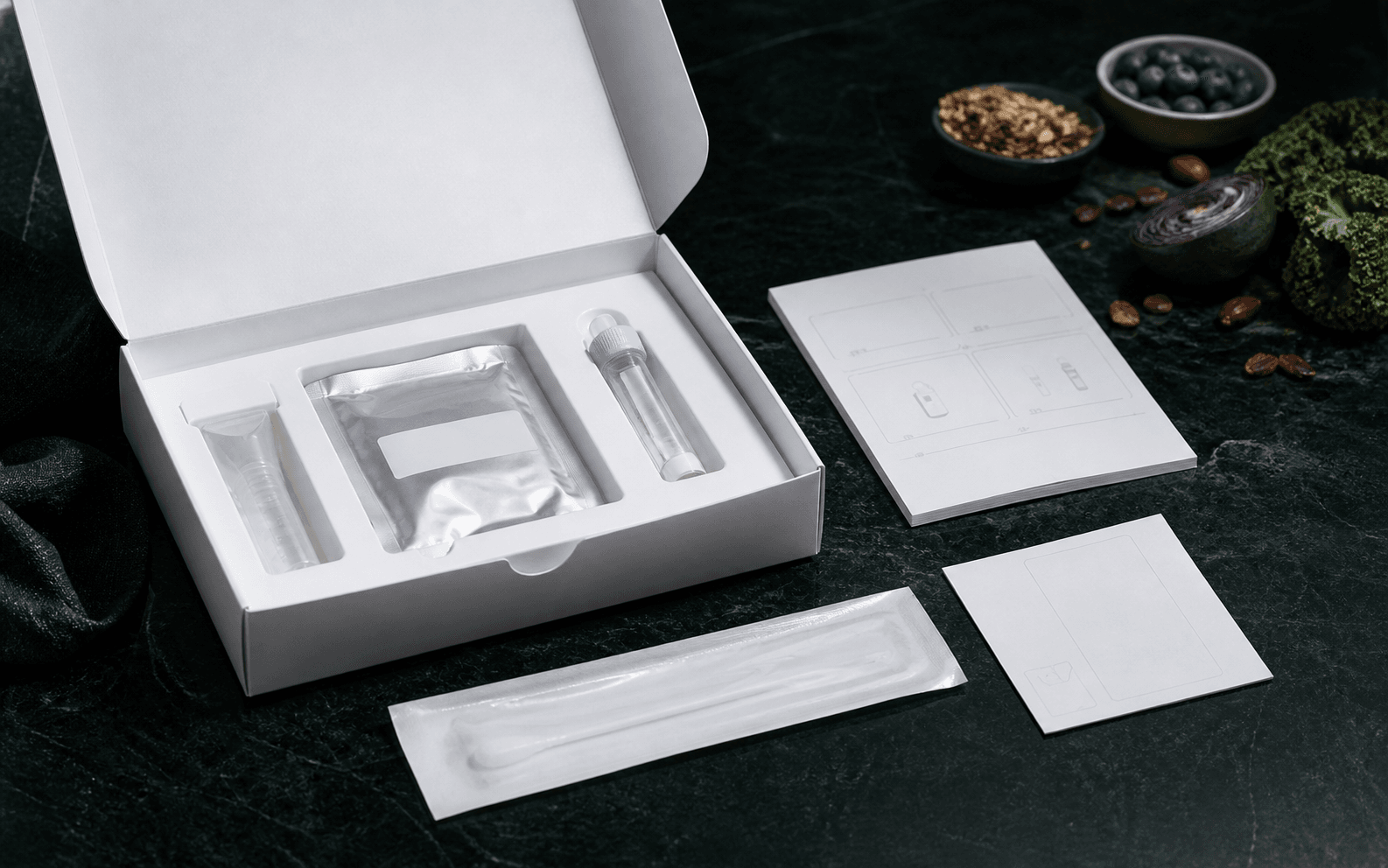 An unbranded gut microbiome sample collection kit arranged on a dark green clinical surface